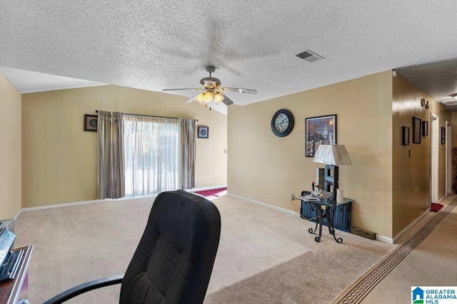 carpeted office space with ceiling fan and a textured ceiling