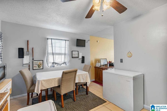 tiled dining space featuring a textured ceiling and ceiling fan