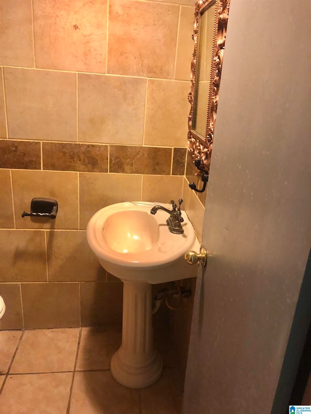 bathroom featuring sink and tile walls