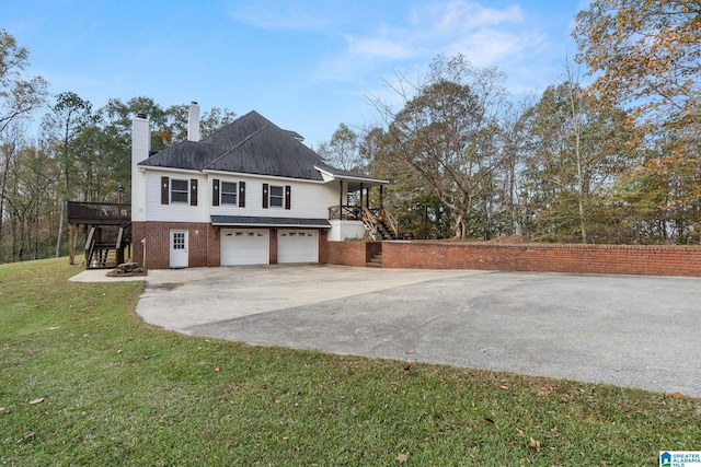 view of home's exterior with a lawn, a deck, and a garage