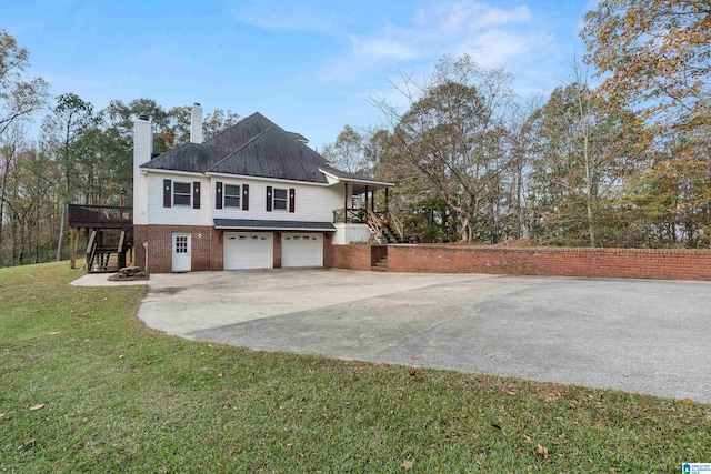 view of side of home with a garage, a deck, and a yard