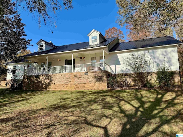 cape cod-style house featuring covered porch and a front yard