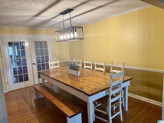 dining area featuring a textured ceiling, dark hardwood / wood-style floors, and crown molding