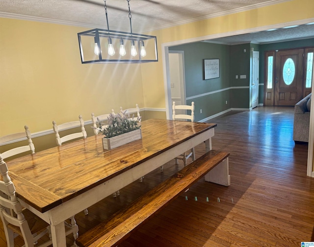 dining area with dark hardwood / wood-style flooring, a textured ceiling, and ornamental molding