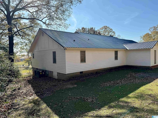 view of home's exterior featuring a lawn and central AC