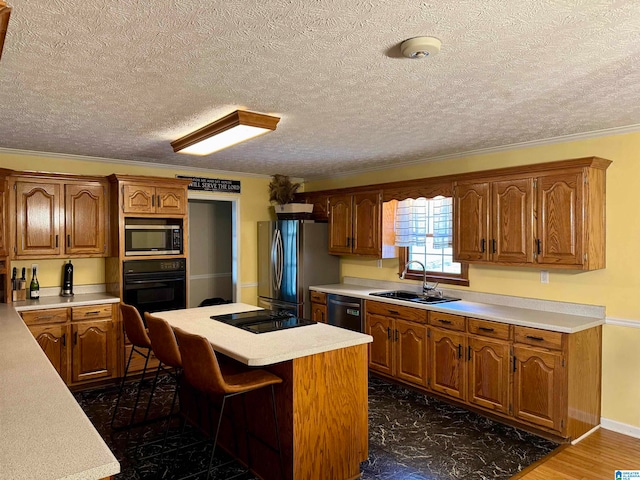 kitchen with a center island, black appliances, sink, dark hardwood / wood-style floors, and ornamental molding