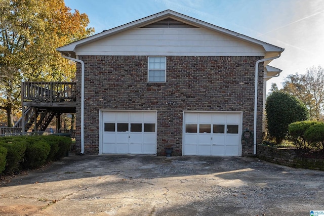 view of home's exterior with a wooden deck and a garage