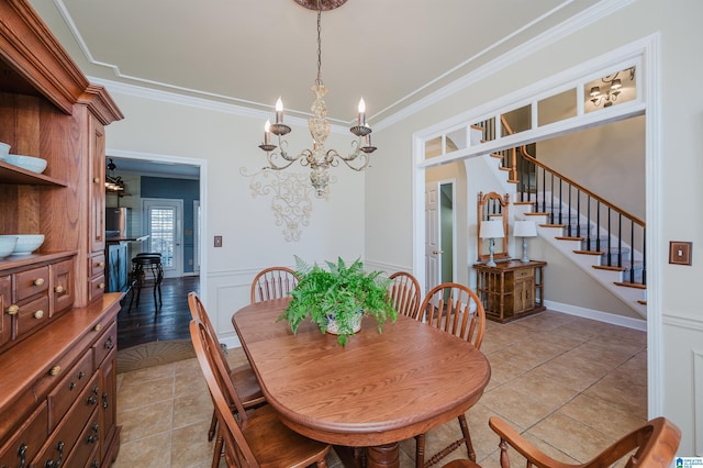 dining room with light tile patterned floors, crown molding, and a chandelier