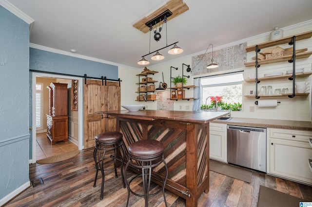 kitchen featuring a barn door, dishwasher, dark hardwood / wood-style flooring, and pendant lighting