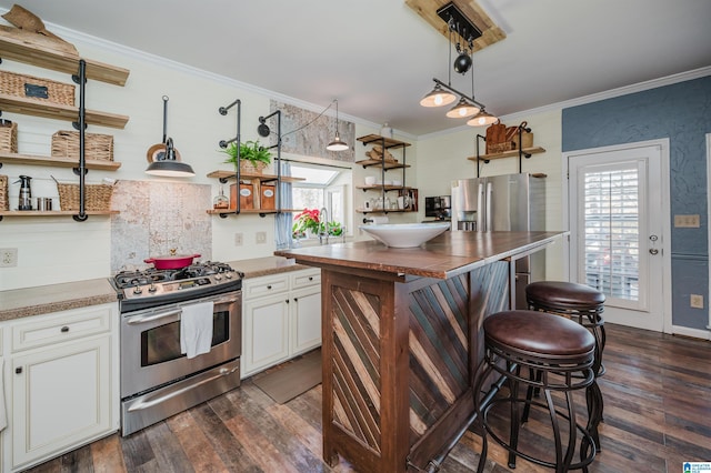 kitchen featuring hanging light fixtures, dark wood-type flooring, crown molding, white cabinets, and appliances with stainless steel finishes