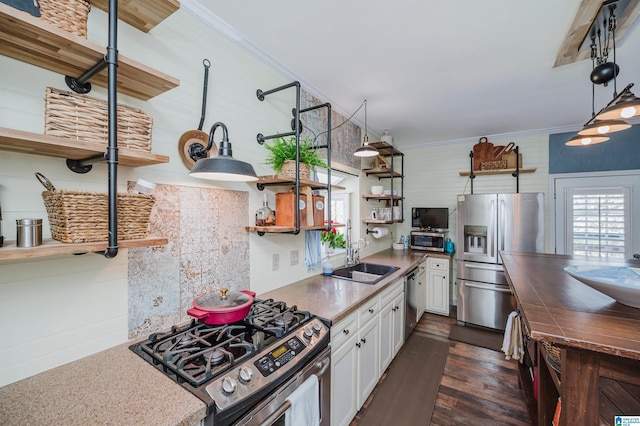 kitchen featuring white cabinets, sink, dark hardwood / wood-style floors, ornamental molding, and appliances with stainless steel finishes