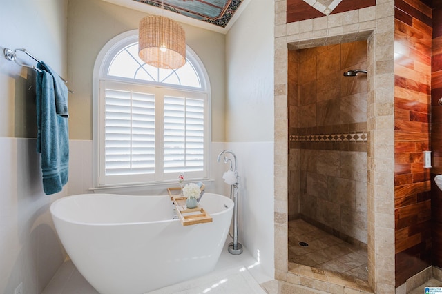 bathroom with plus walk in shower, a wealth of natural light, and tile walls