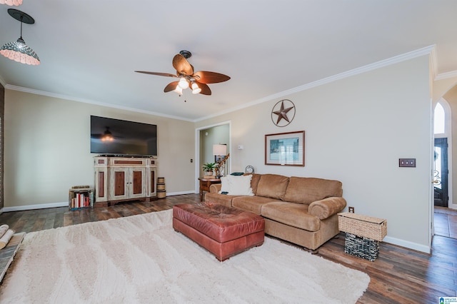 living room with ceiling fan, dark wood-type flooring, and ornamental molding