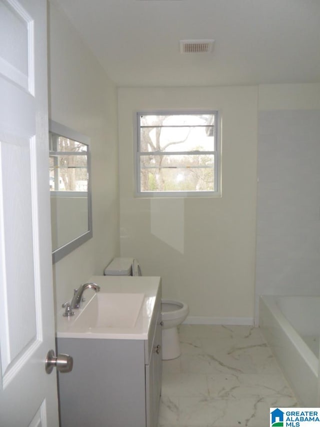 bathroom featuring plenty of natural light, toilet, a tub, and vanity