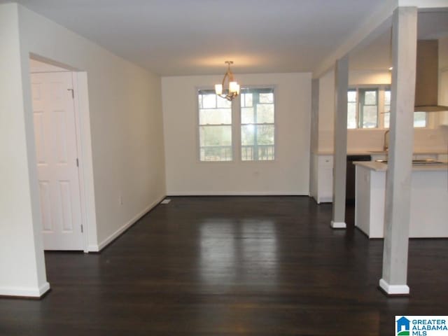 unfurnished dining area featuring a chandelier and dark hardwood / wood-style floors