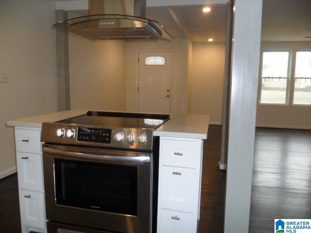 kitchen with dark wood-type flooring, a kitchen island, electric stove, white cabinets, and exhaust hood