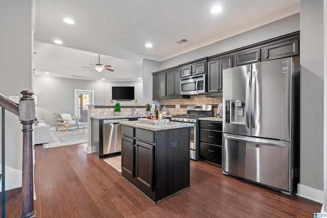 kitchen featuring tasteful backsplash, a kitchen island, dark hardwood / wood-style floors, and appliances with stainless steel finishes