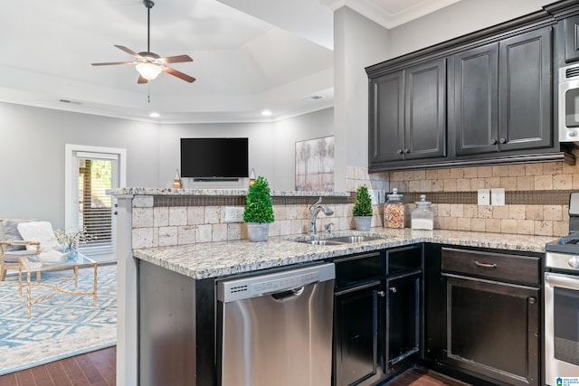 kitchen with appliances with stainless steel finishes, dark hardwood / wood-style floors, tasteful backsplash, and ornamental molding