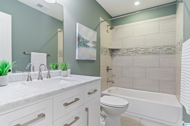 full bathroom with vanity, tiled shower / bath combo, and toilet