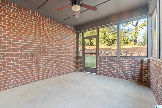 unfurnished sunroom featuring ceiling fan