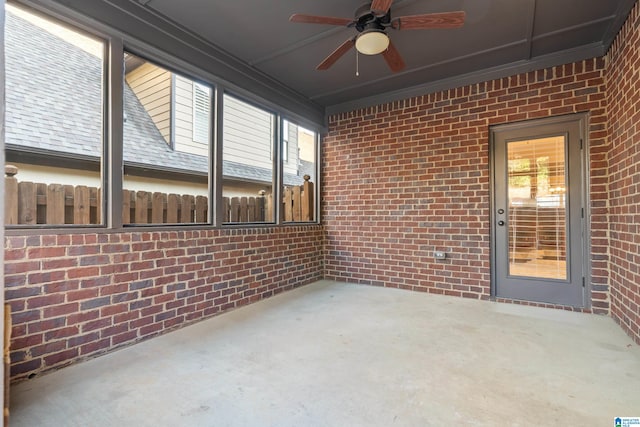 unfurnished sunroom with ceiling fan