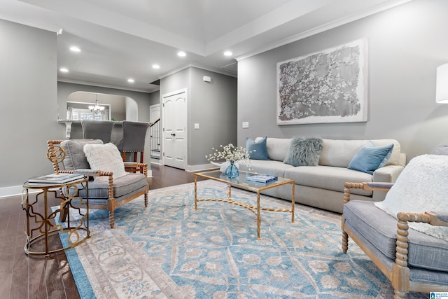 living room with ornamental molding, dark wood-type flooring, and a chandelier