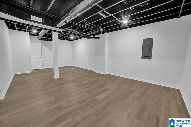 basement featuring hardwood / wood-style floors and electric panel