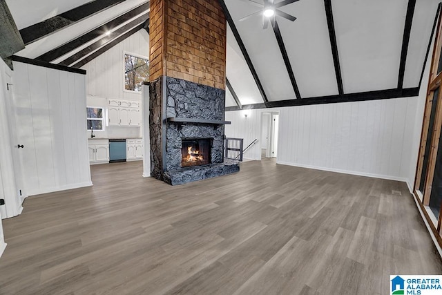 unfurnished living room featuring beam ceiling, ceiling fan, a fireplace, and high vaulted ceiling