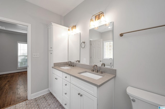 bathroom featuring a wealth of natural light, toilet, vanity, and hardwood / wood-style flooring