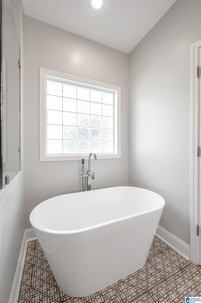 bathroom featuring tile patterned flooring and a tub to relax in