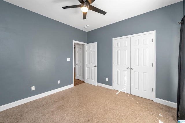 unfurnished bedroom featuring carpet, ceiling fan, and a closet