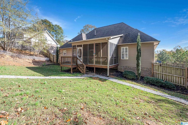 back of house featuring a lawn and a sunroom