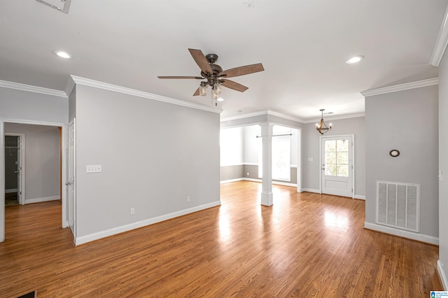 unfurnished living room featuring ornate columns, light hardwood / wood-style flooring, ceiling fan with notable chandelier, and ornamental molding