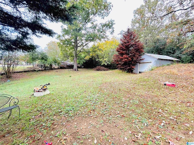 view of yard featuring a garage and an outbuilding