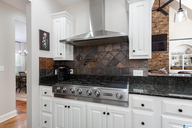 kitchen with wall chimney exhaust hood, pendant lighting, white cabinets, hardwood / wood-style floors, and stainless steel gas stovetop