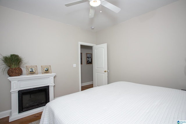 bedroom with dark hardwood / wood-style flooring and ceiling fan