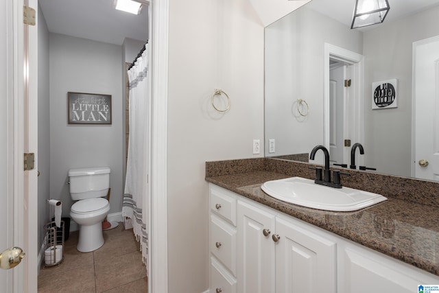 bathroom featuring tile patterned flooring, vanity, toilet, and walk in shower