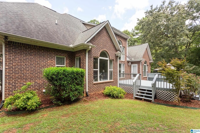 view of side of home with a deck and a yard