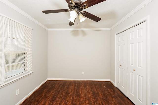 unfurnished bedroom featuring ceiling fan, ornamental molding, dark wood-type flooring, and multiple windows