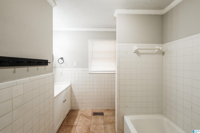 bathroom featuring a tub, tile patterned flooring, crown molding, vanity, and tile walls