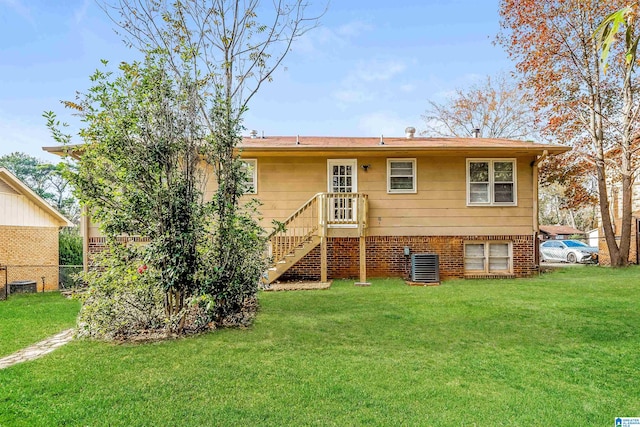 rear view of property with central air condition unit and a lawn