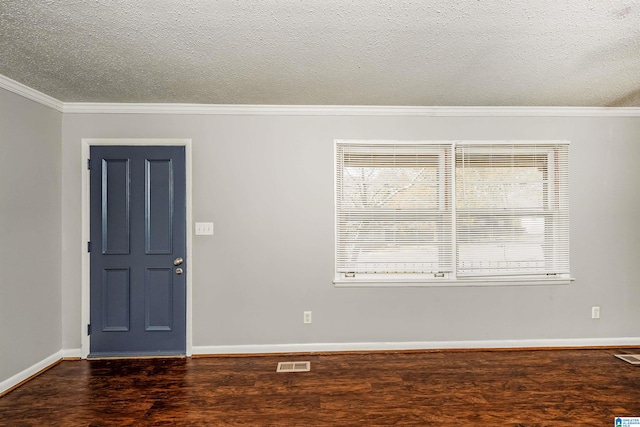 unfurnished room featuring a textured ceiling, ornamental molding, and dark wood-type flooring