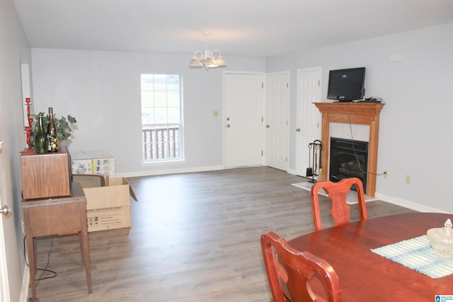 dining space with hardwood / wood-style flooring, a chandelier, and a tile fireplace