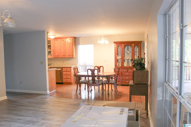 dining space featuring light hardwood / wood-style flooring and a notable chandelier