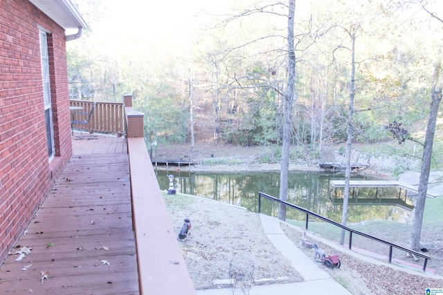 wooden terrace with a water view and a boat dock