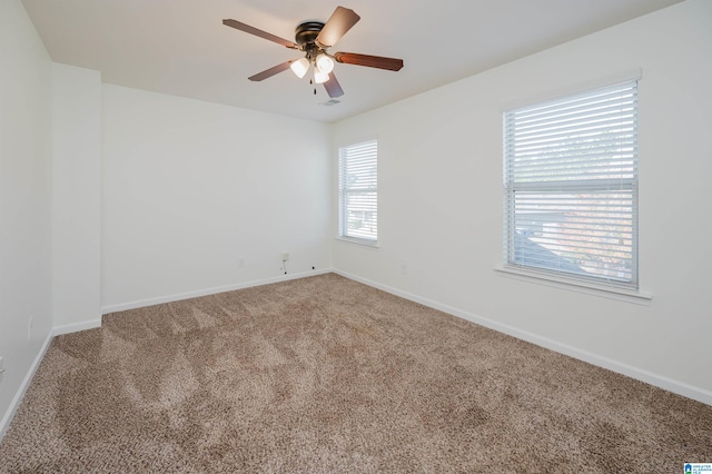 empty room with ceiling fan, carpet floors, and a wealth of natural light