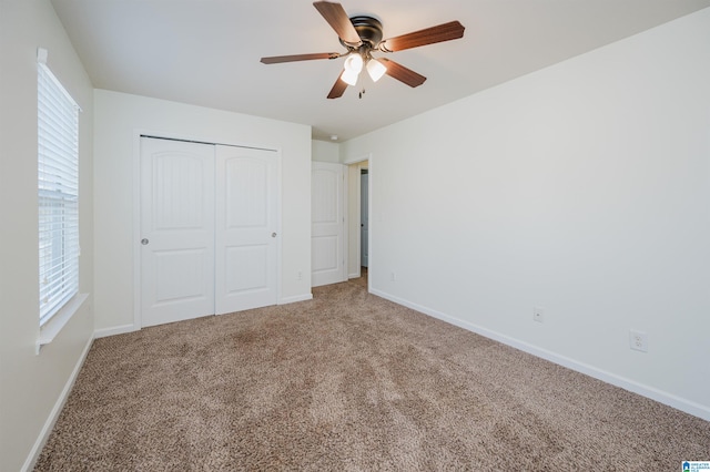 unfurnished bedroom with carpet floors, a closet, multiple windows, and ceiling fan