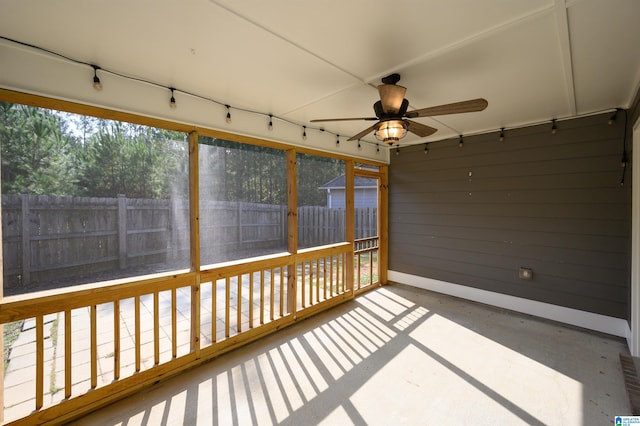 unfurnished sunroom featuring ceiling fan