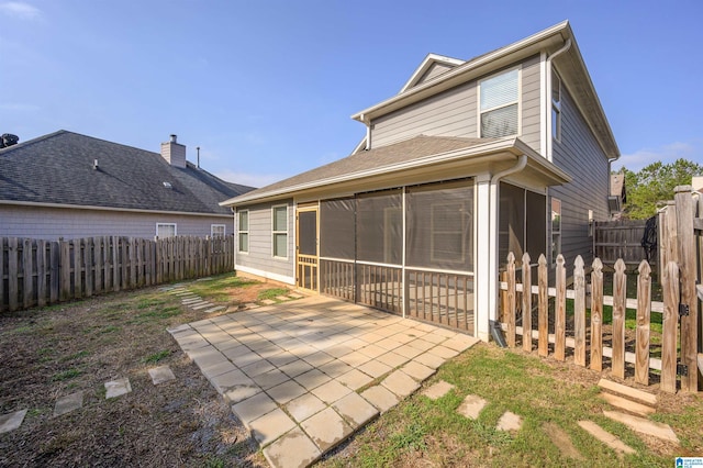 rear view of property featuring a patio and a sunroom