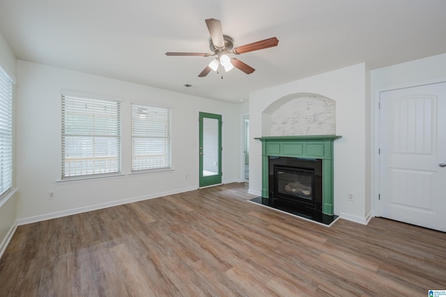 unfurnished living room with wood-type flooring and ceiling fan